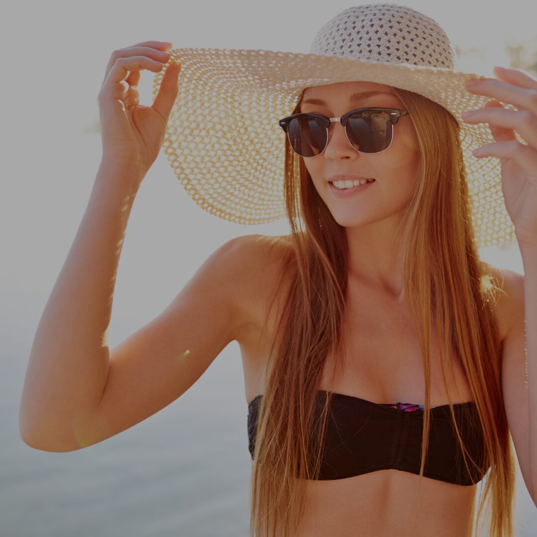 Vrouw met zwarte bikini zonnebril en witte hoed op van de blog 10 Zomertips voor een Stralende Huid