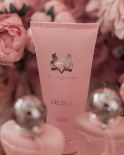 close up van roze tube tussen bloemen van de parfums de marly showergel
