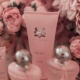 close up van roze tube tussen bloemen van de parfums de marly showergel