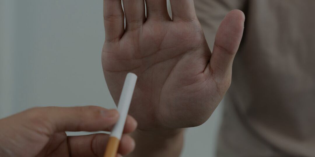 Wat Roken met je Huid Doet : Foto iemand bied een sigaret aan en wordt tegen gehouden met een hand