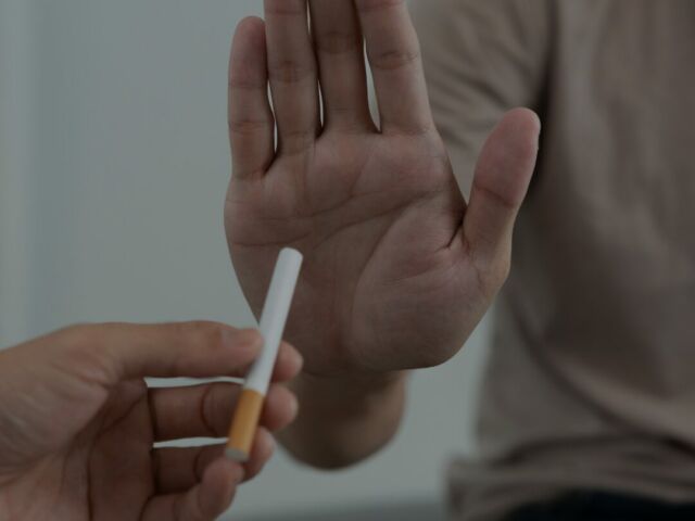 Wat Roken met je Huid Doet : Foto iemand bied een sigaret aan en wordt tegen gehouden met een hand
