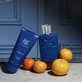 blauwe parfumfles en blauwe tube met er rondom heen manderijnen van Parfums de Marly Percival